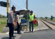 Personel Sat Binmas Polres Kediri memberikan rompi keselamatan kepada relawan penjaga palang pintu perlintasan kereta api.